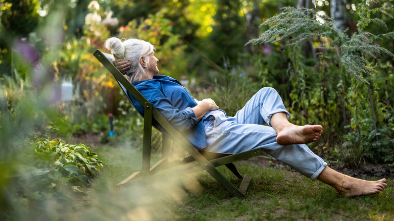A older woman relaxing in her garden