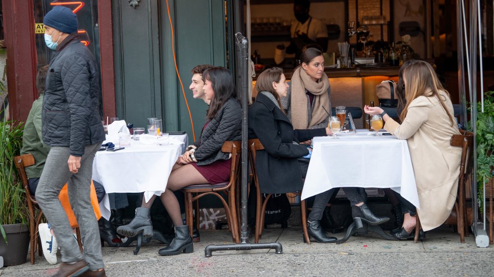 Men and women dine outdoors