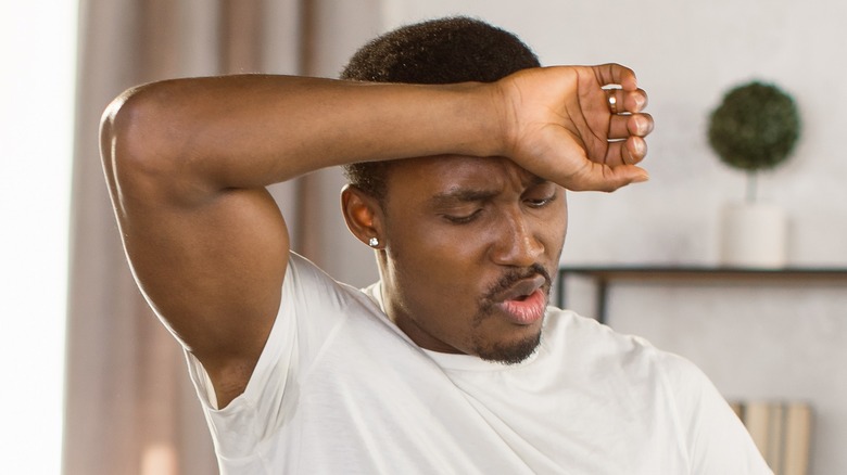 Man wiping forehead sweat