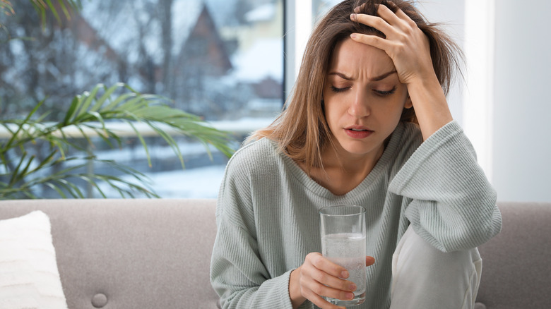 Sick woman holding water glass