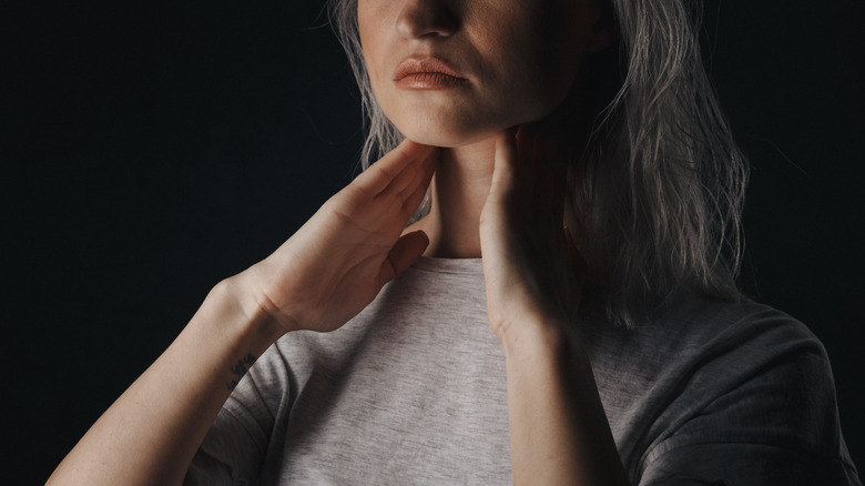 Woman checking her thyroid gland