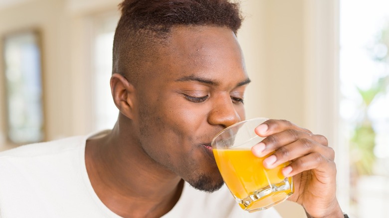 man drinking orange juice