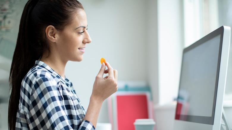 Young woman eating dried apricot