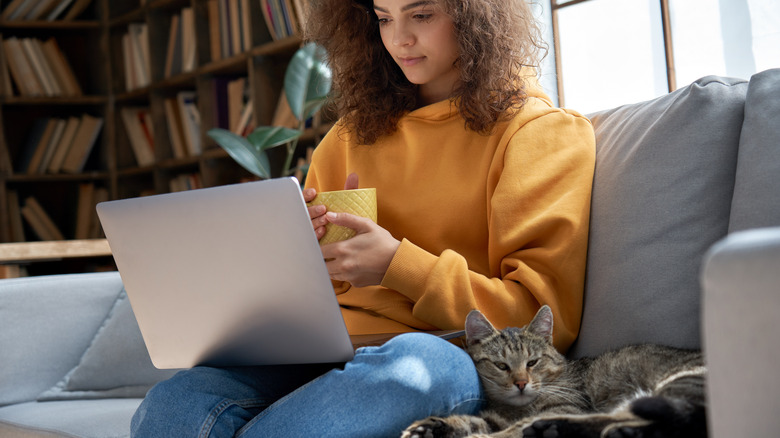 Woman with cat lying beside her