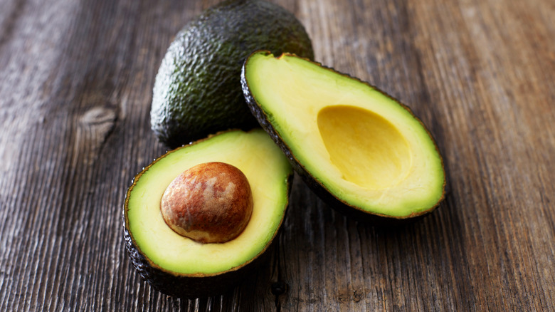 A sliced avocado on a wood table