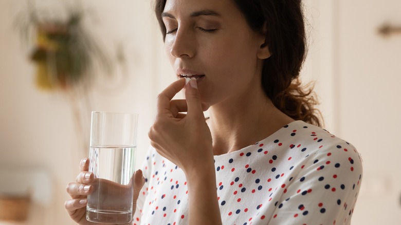 Woman taking medication with water
