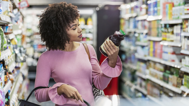 woman looking at food label on juice