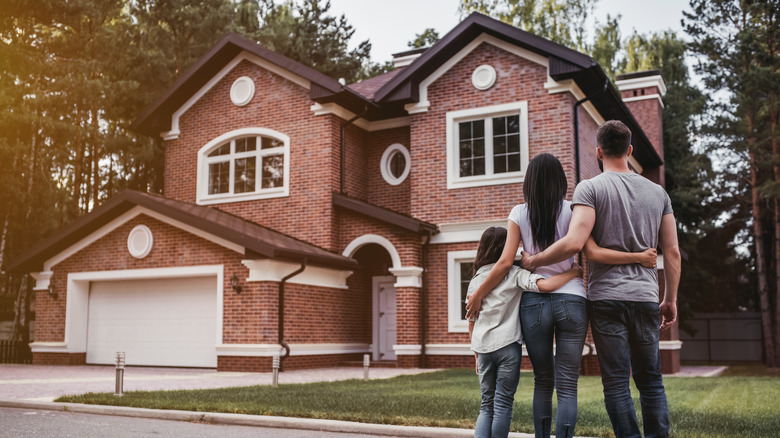 Family standing in front of home