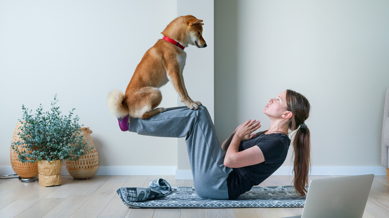 Woman doing yoga with her dog