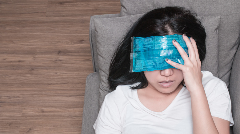 Woman with a cold pack over her eyes