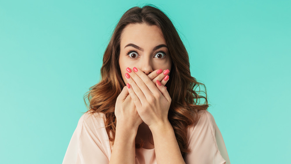 surprised woman covering mouth