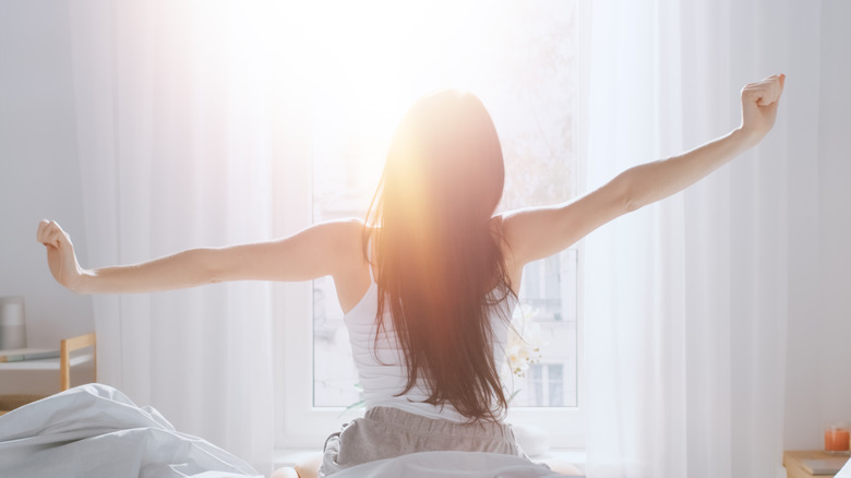young woman stretching after waking up in the morning