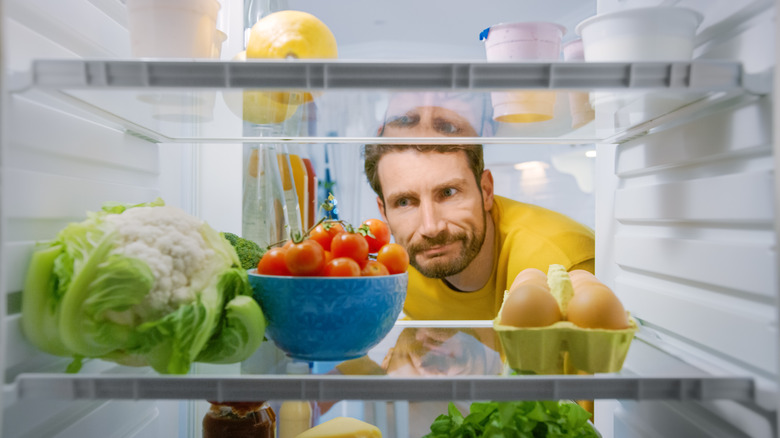 Man standing in front of open fridge