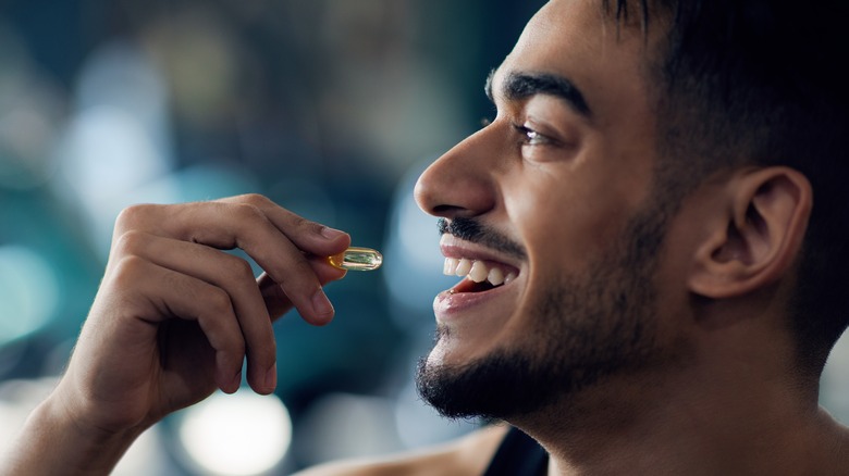 Healthy smiling man taking antibiotics