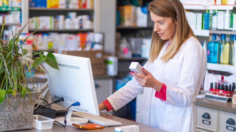 Pharmacist researches medication via laptop