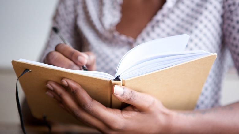 person writing in a book