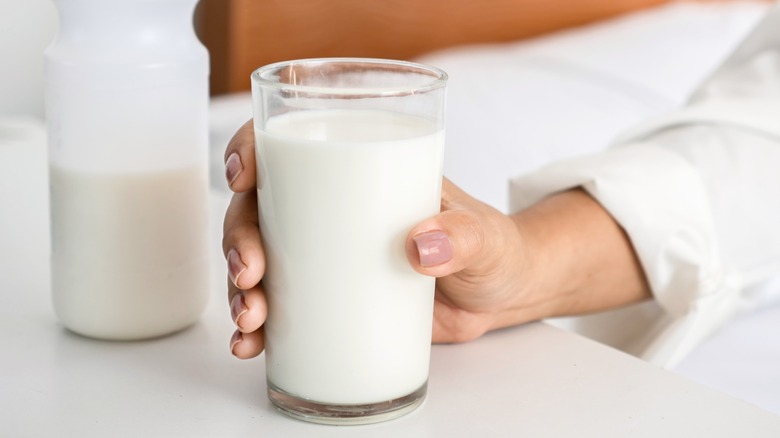 person holding glass of milk