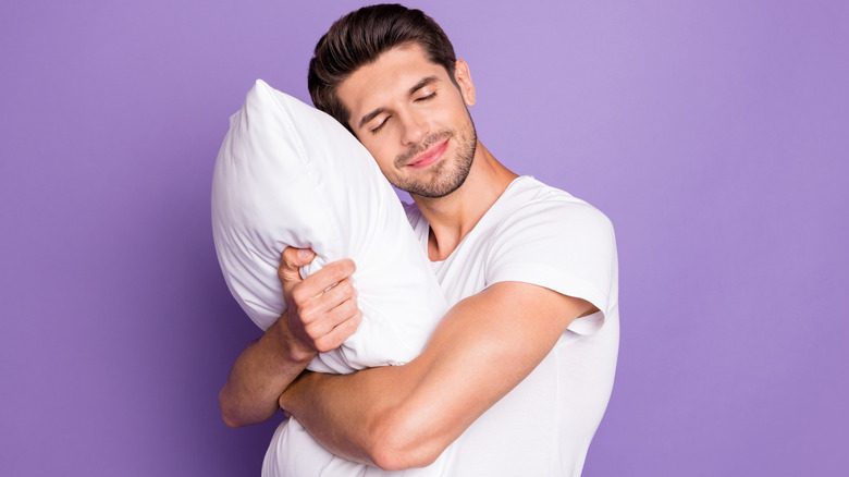 man hugging pillow