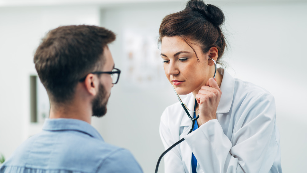 doctor listening to patient's heart with stethoscope