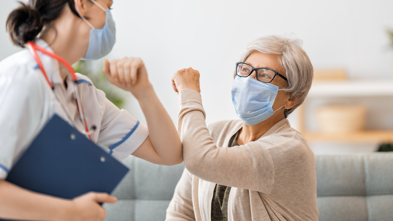 medical professional elbow bumps with patient