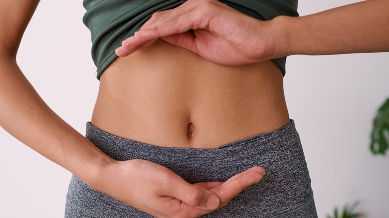 woman with hands on stomach