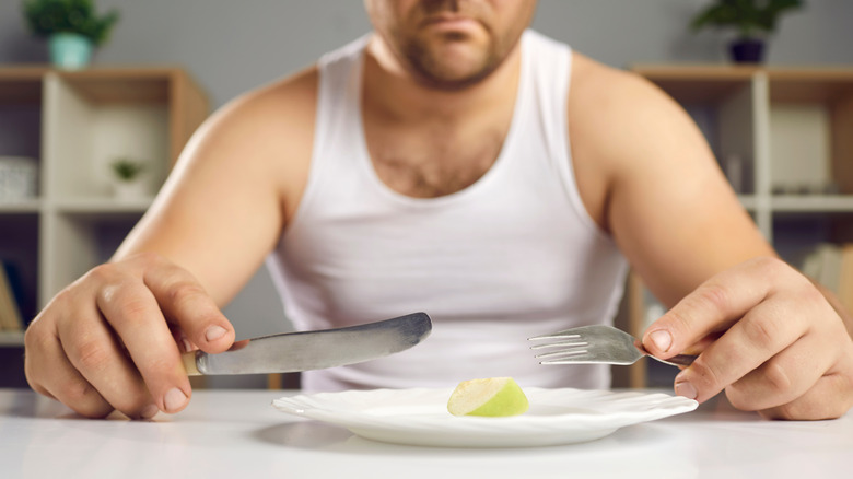 Man in front of plate with small portion 