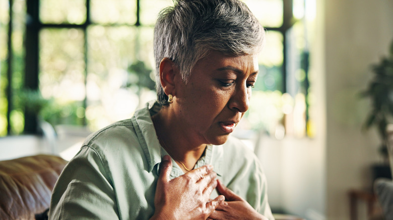 woman with heartburn holding chest