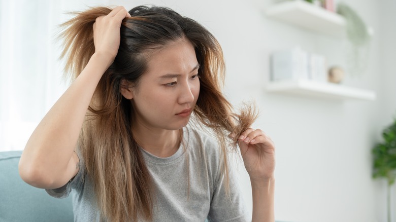 Woman looking at damaged hair