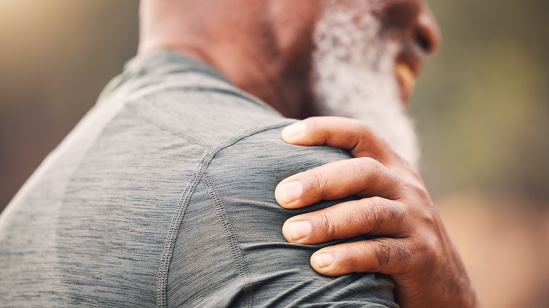 Man holding shoulder in pain