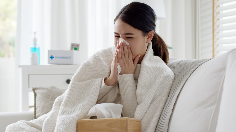 Woman blowing nose in tissue