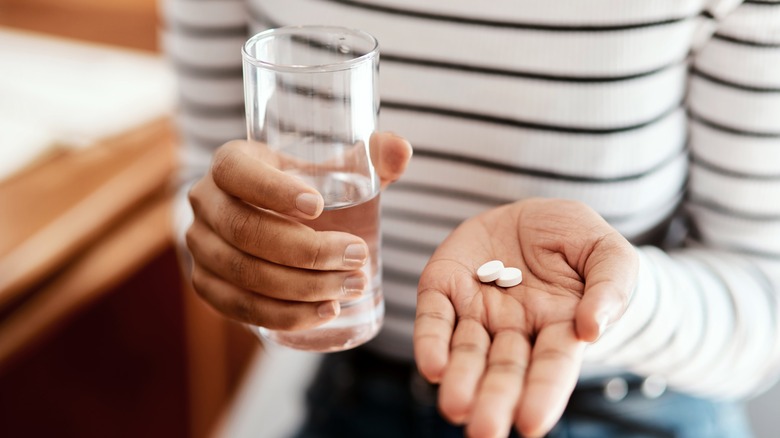 Hand holding two white pills