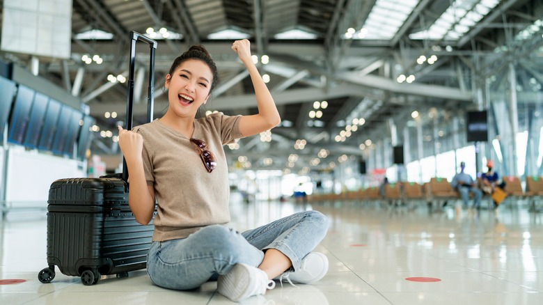 a teenager sitting on the airport floor 