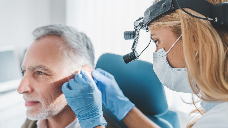 man at a doctor visit having his ear checked