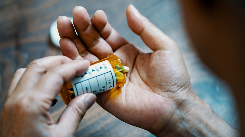 A man's hands dispensing medication