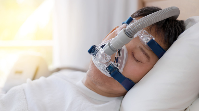 person sleeping and using CPAP machine
