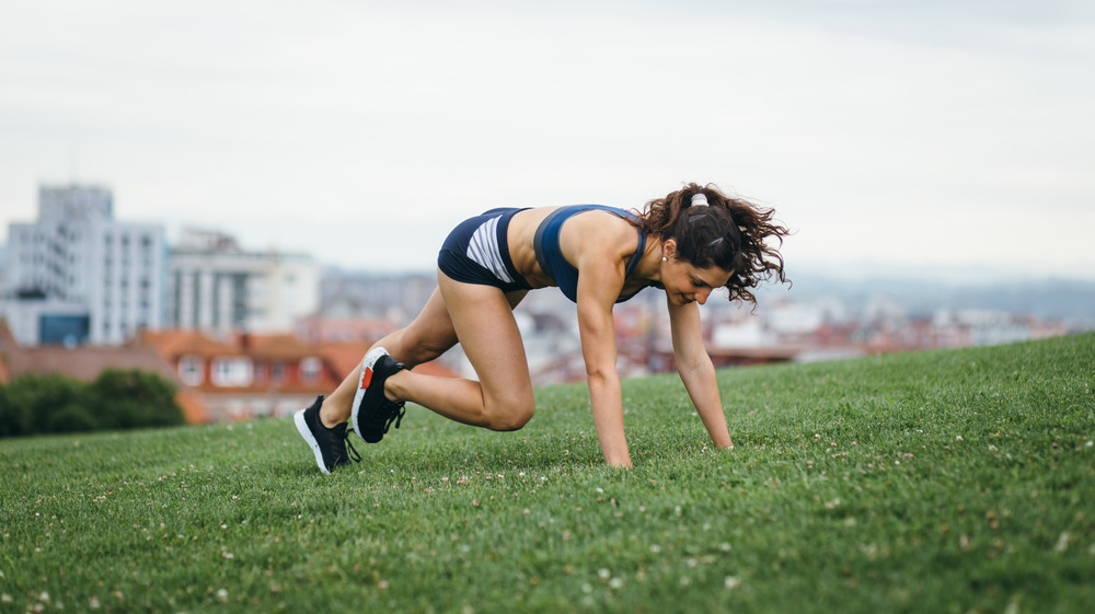 woman doing burpees outside