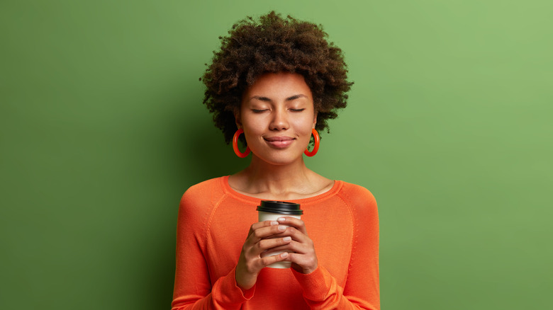 A woman enjoys a cup of coffee