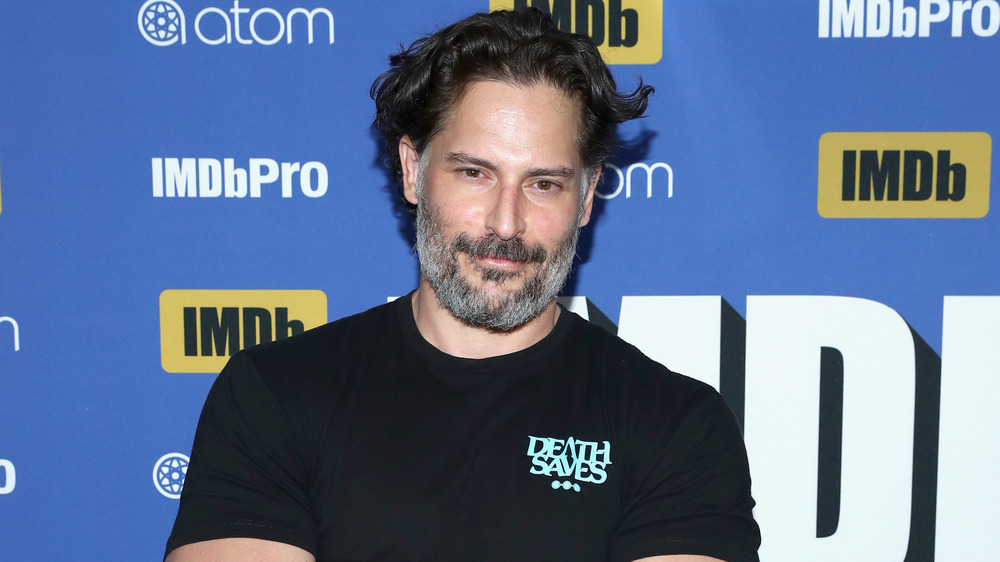 Joe Manganiello grinning wearing a black t-shirt 