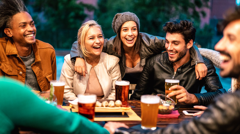 Friends sitting around a table drinking beer