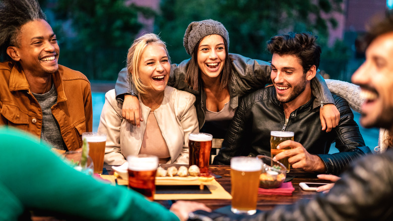 Friends sitting around a table drinking beer