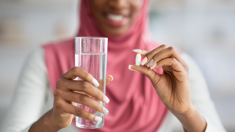 woman holding vitamin and water