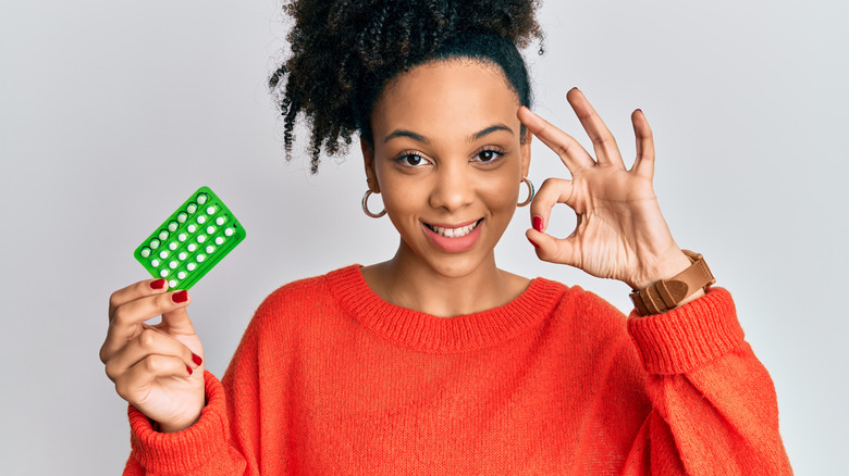 woman holding birth control pills