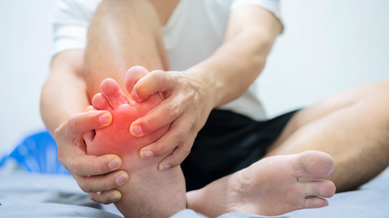 person with gout holding feet