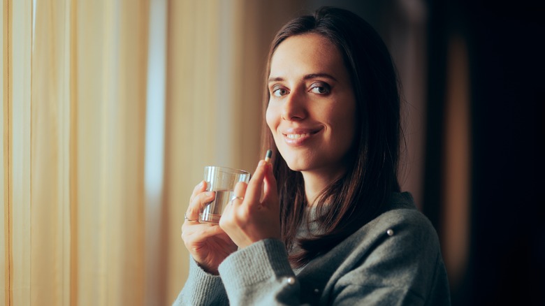 Woman taking pill with water