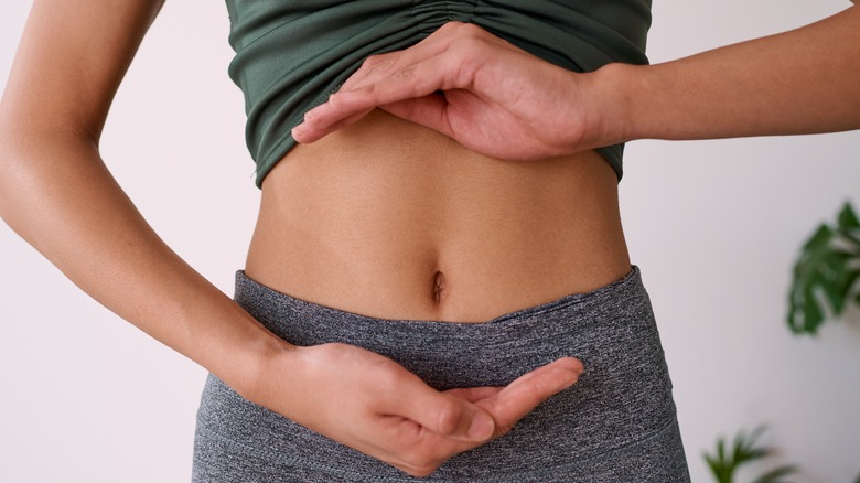 Woman with hands circling abdomen