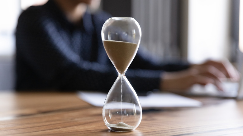 Hourglass and person typing