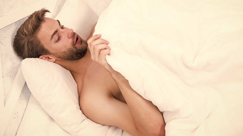 Man looking under blanket