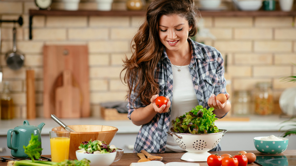 Woman making a salad in a kitchen.