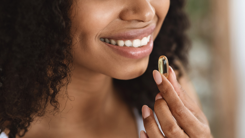 Woman holding pill 