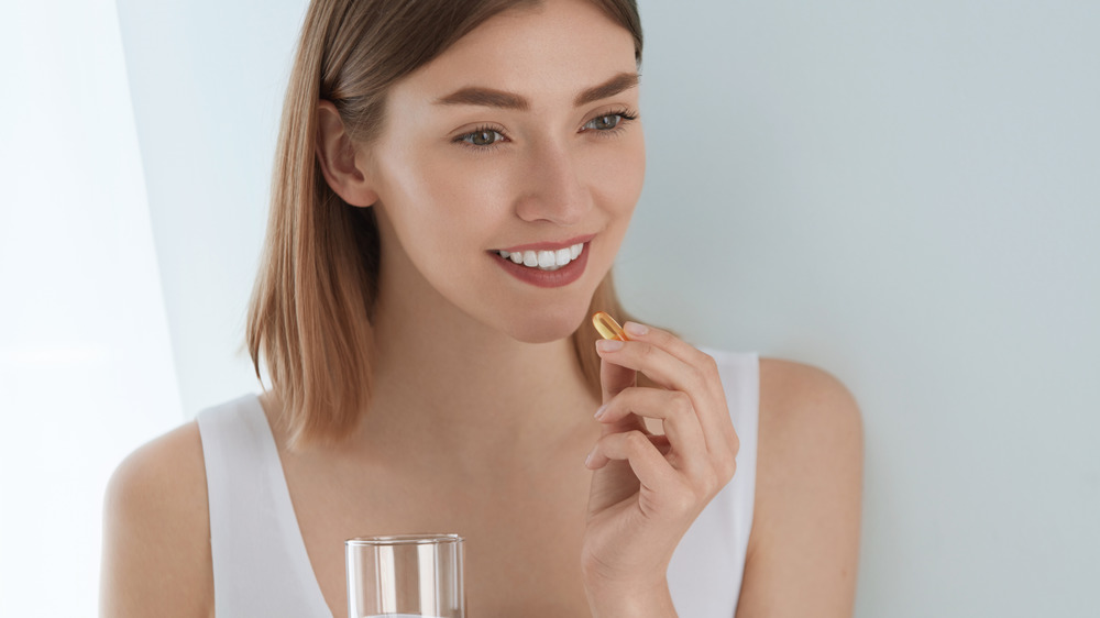 Woman holding pill 